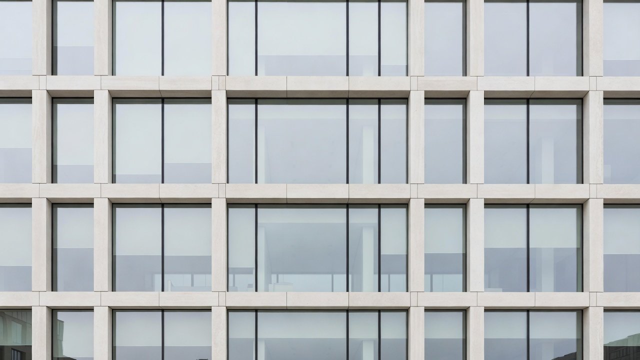 Modern European institutional building facade with glass and stone under daylight